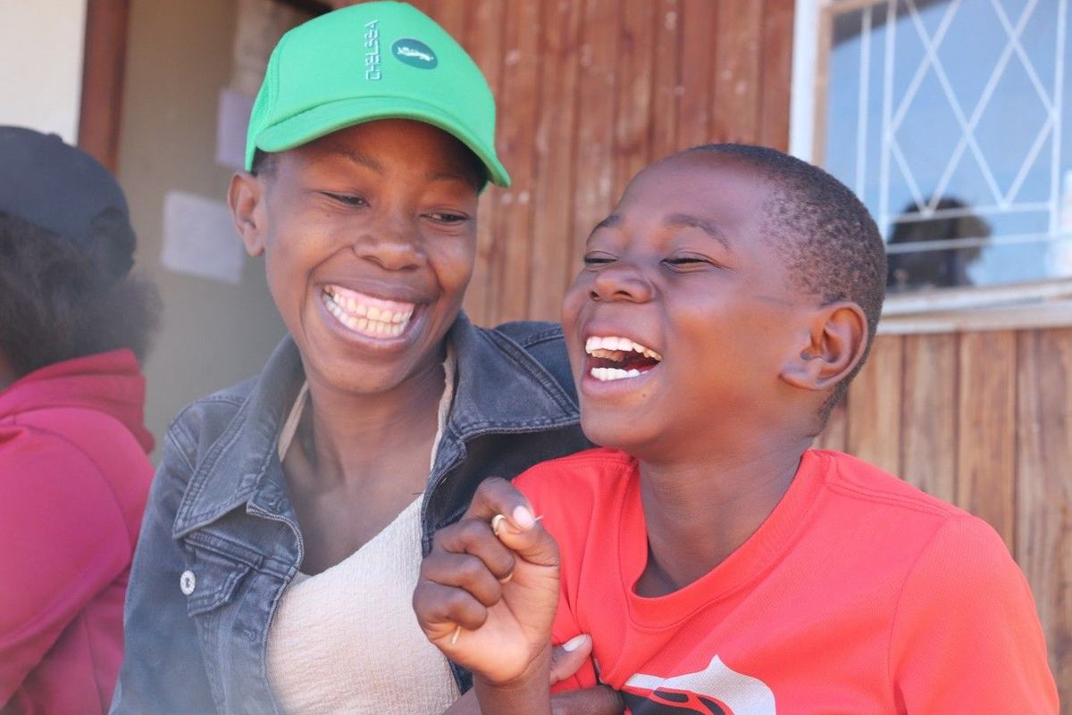 A mother and son share laughter during a programme providing fortified food to families.