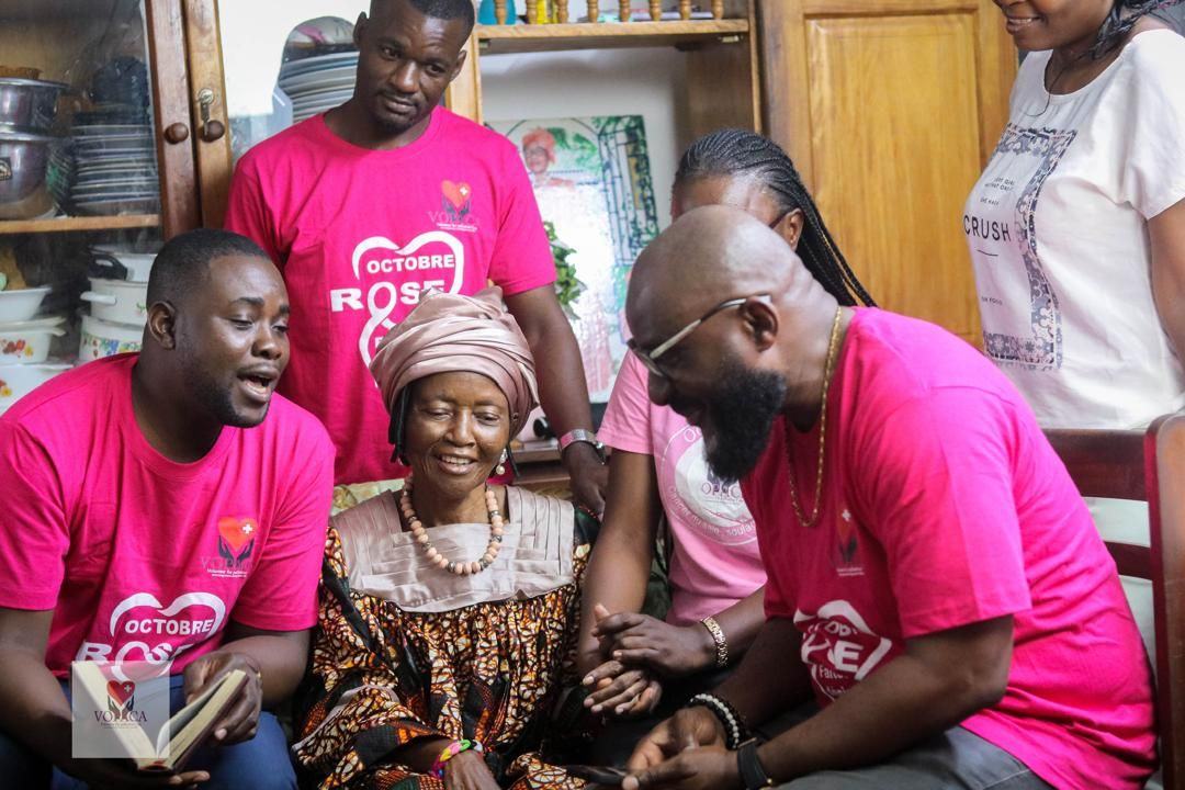 Volunteers gather around a patient for a shared moment of prayer and spiritual support.