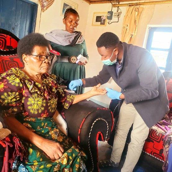 A palliative care team visits an older woman at home in Kipagalo Ward.
