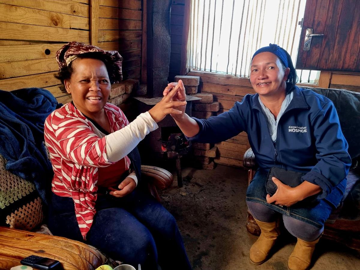 A woman recovering from a stroke shares a moment with her caregiver.