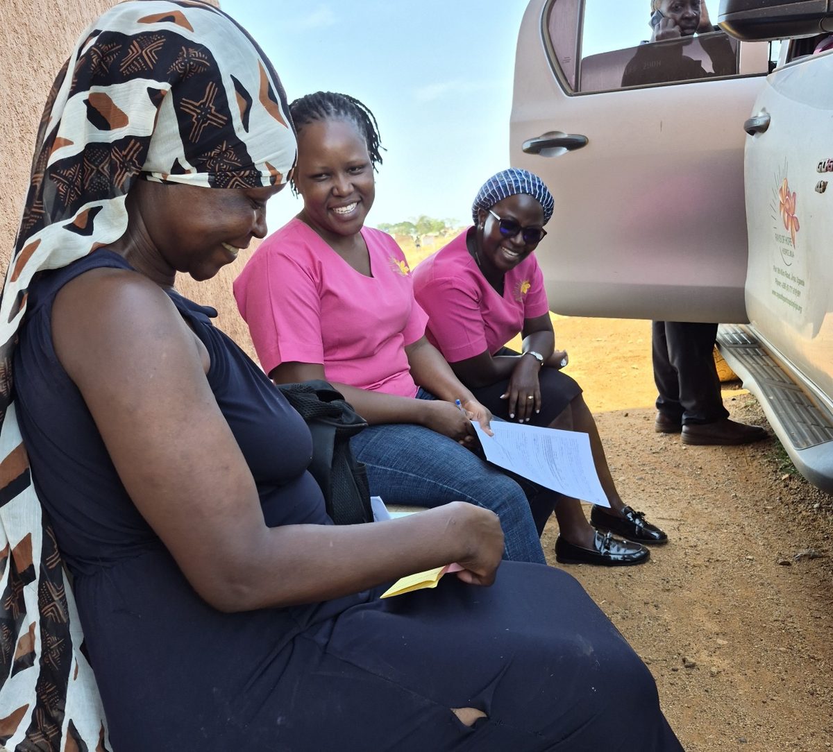 Shadia laughing with the Rays of Hope Hospice Jinja palliative care team