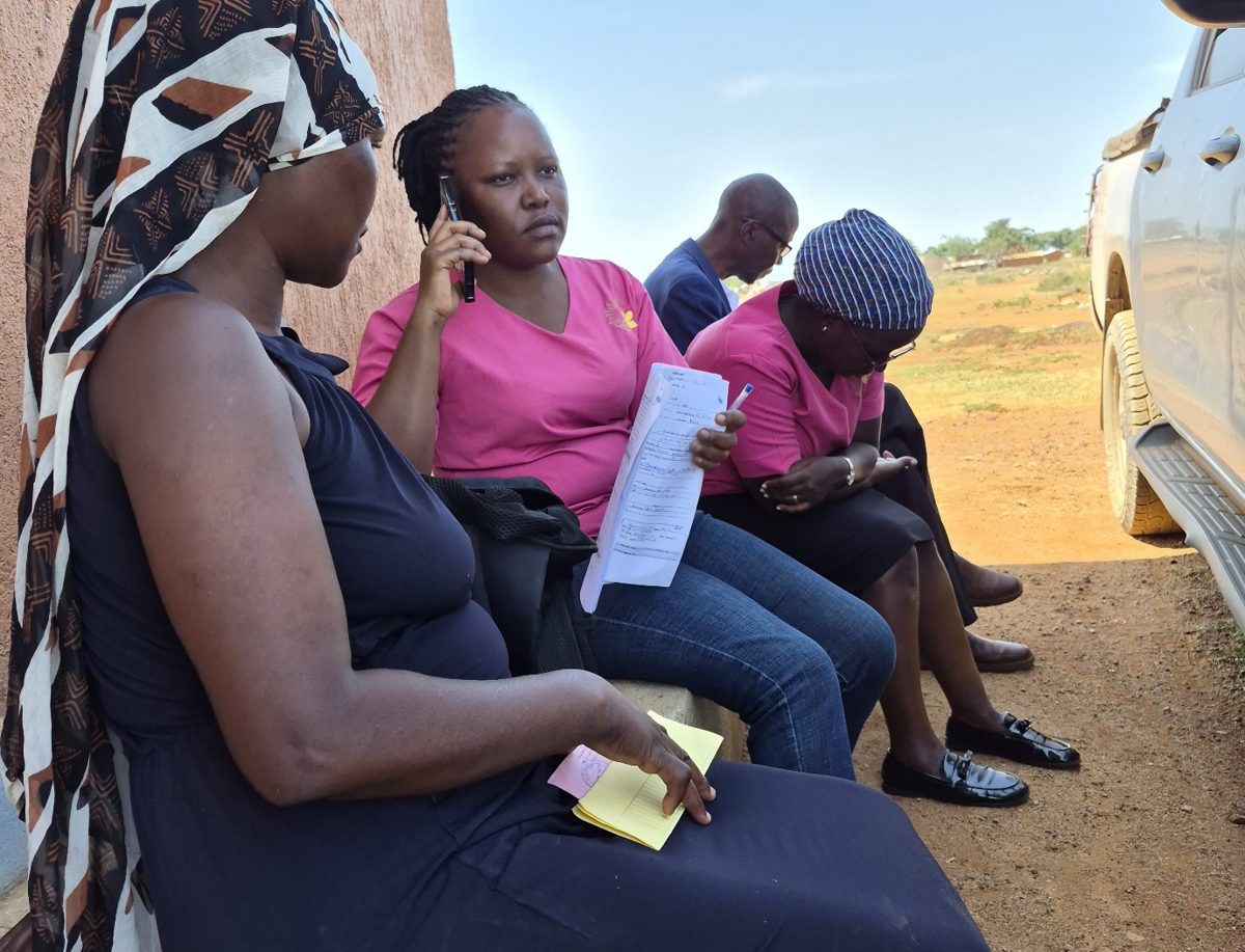 Irene, a clinical officer, on the phone to Jinja Hospital to arrange a referral for Shadia