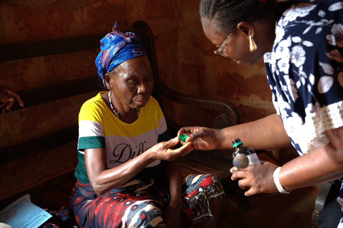 Fourth place: palliative care nurse Sidonie explains morphine to her patient during a home visit in Djakotomey, Benin